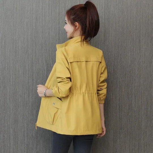 Water-repellent long trench coat for women, featuring an adjustable waist, ideal for spring outerwear.