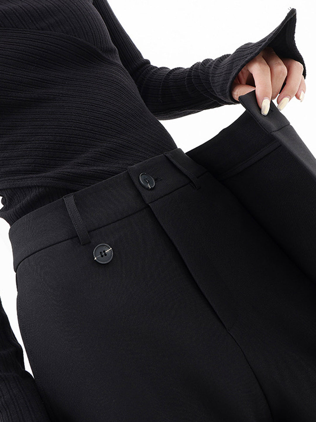 Fashionable women's black asymmetrical trousers, featuring a contemporary relaxed fit for modern style.