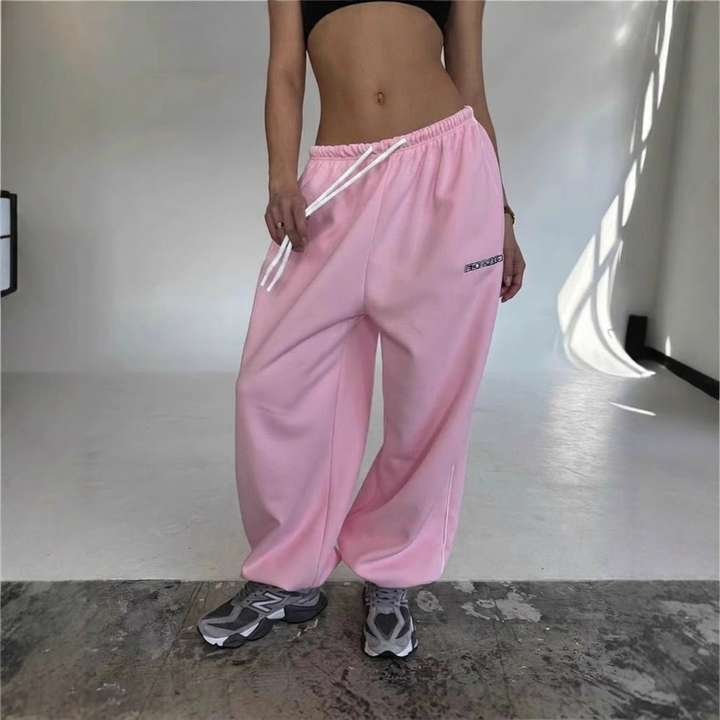Relaxed fit women's sweatpants featuring a stylish side stripe & drawstring, great for comfort.