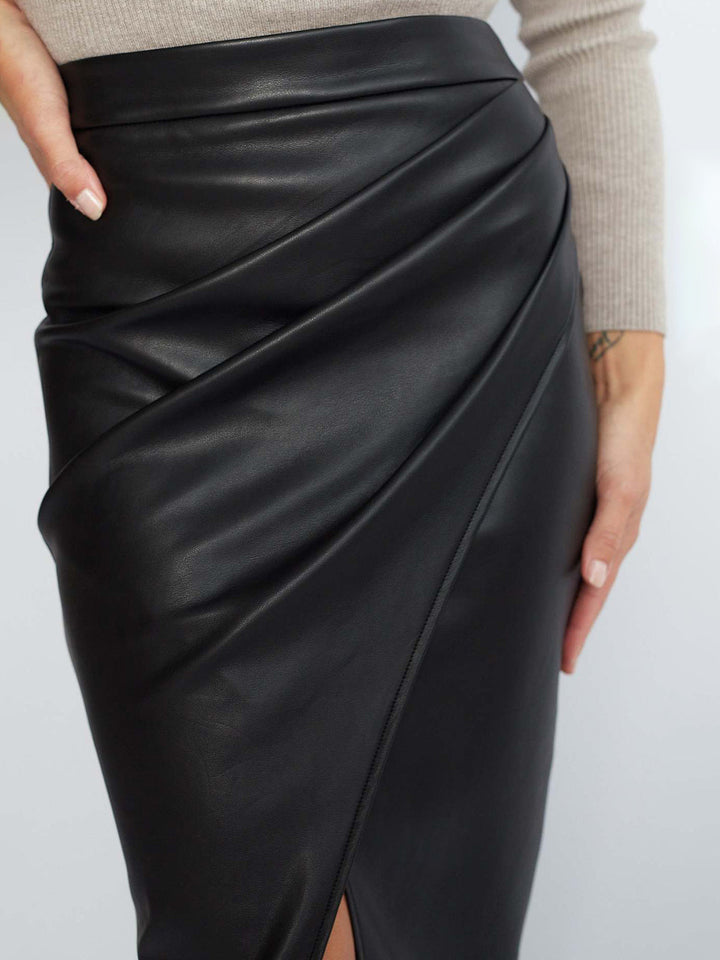 Stylish women's black asymmetrical midi skirt with pleats, offering modern versatility.
