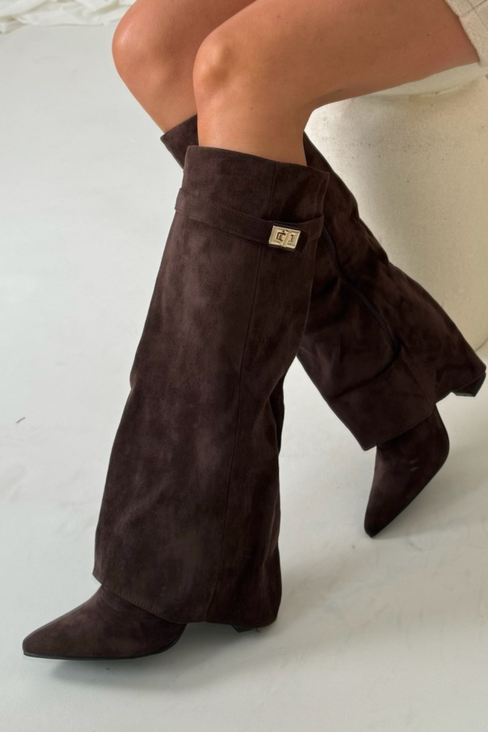 Classic black knee-high boots for women with a sturdy block heel, sharp pointed toe, and unique flap accent.