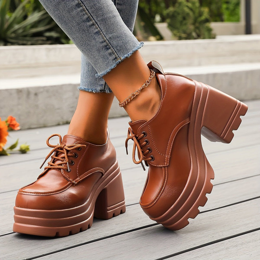 Designer quality women's footwear: black platform oxford shoes with a stylish chunky heel.