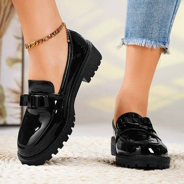 Glossy women's slip-on platform loafers with a stylish bow, comfortable height, and durable lug sole.