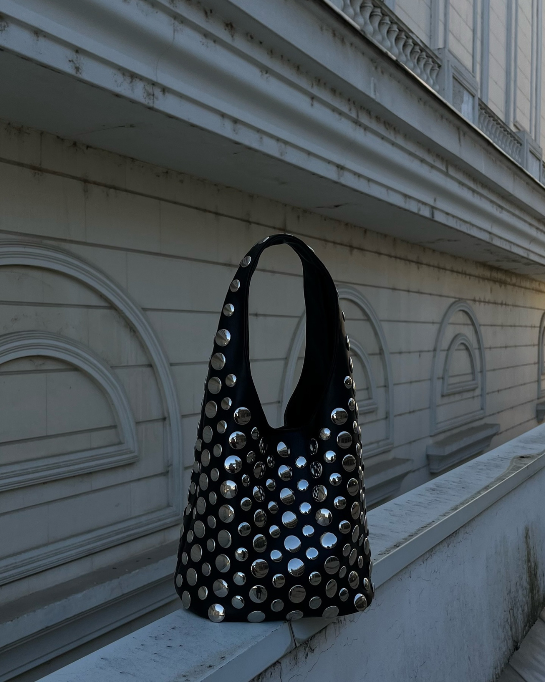 Women's black studded rivet shoulder bag, a stylish evening handbag and fashion accessory.