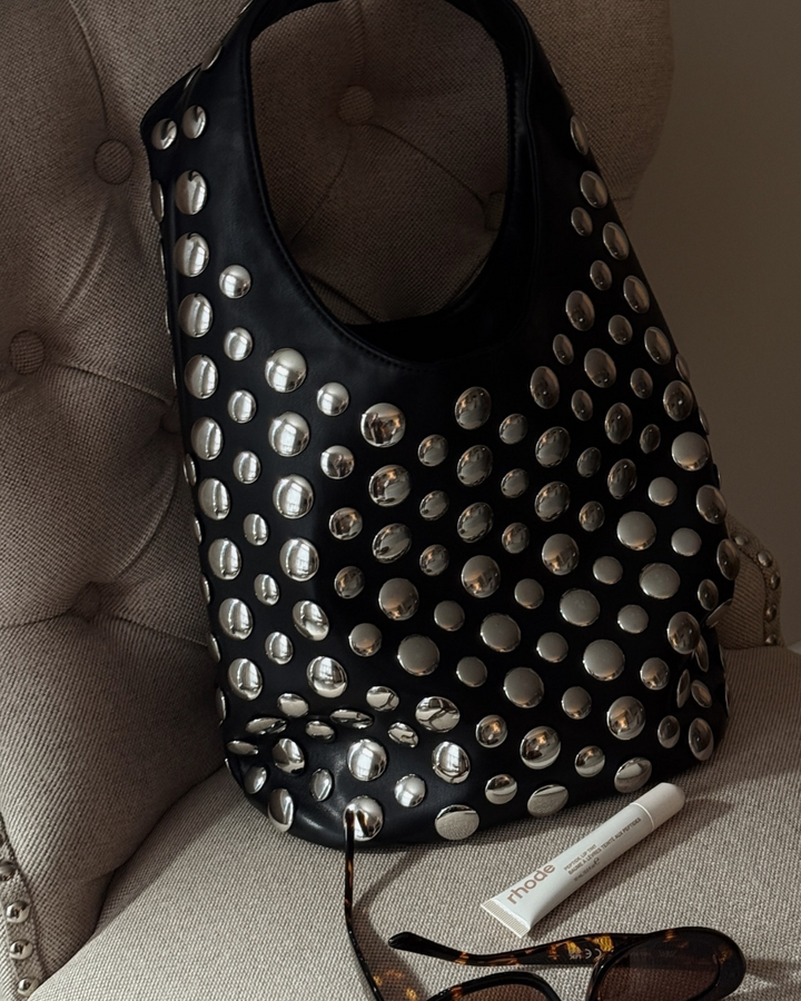 Fashionable women's black shoulder bag with studded rivet details, perfect as a chic evening handbag.