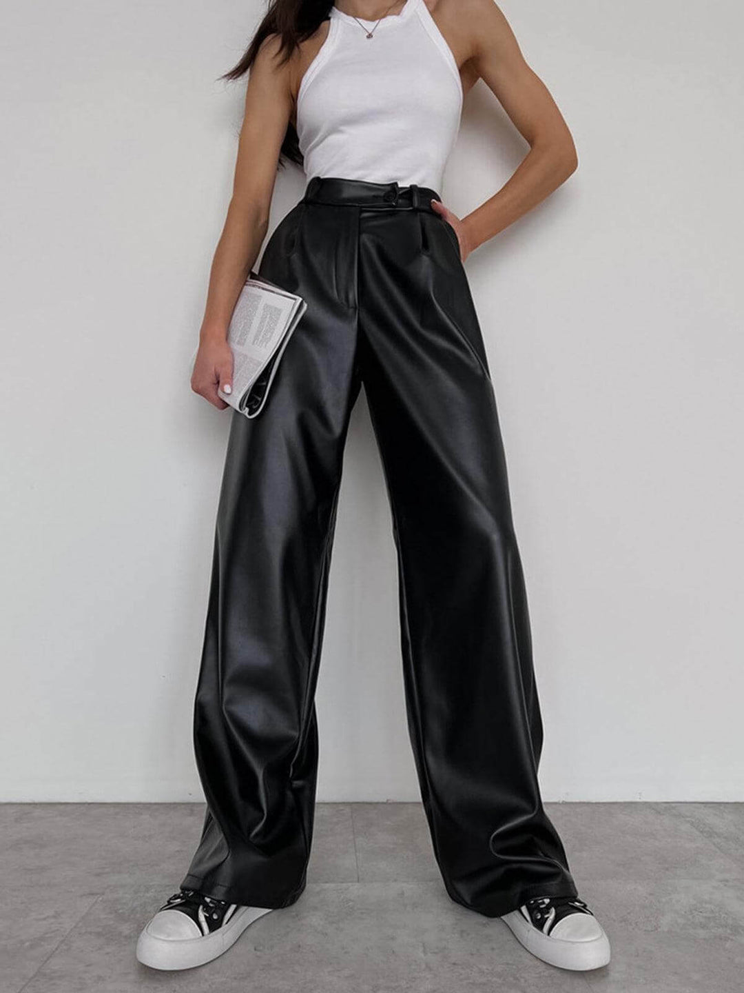 Women's black wide-leg faux leather trousers. Chic, stylish, & comfortable for versatile day or evening wear.