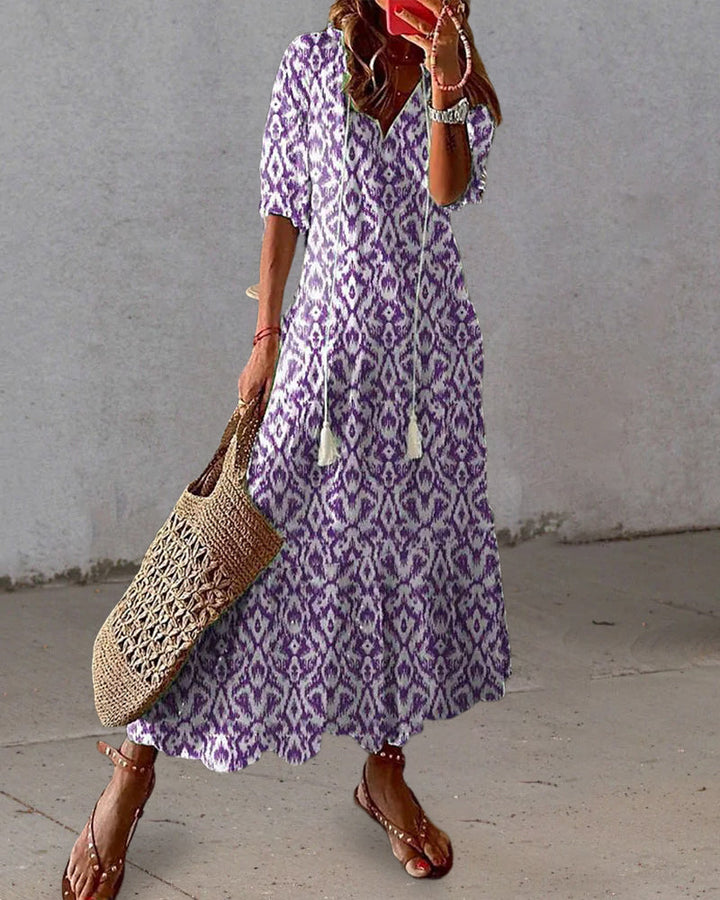 Elegant V-neck women's maxi dress featuring a colorful vintage print. Bohemian style for casual spring/summer wear.