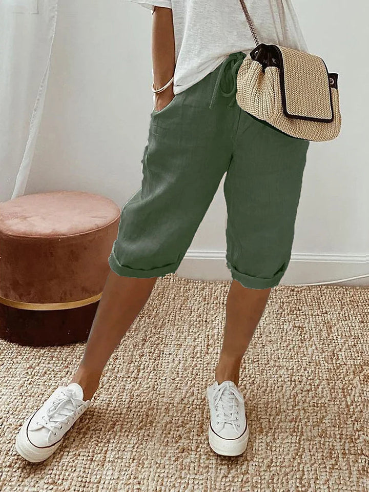 Stylish women's knee-length capri pants from the side, elastic waist & drawstring for versatile, comfy everyday wear.