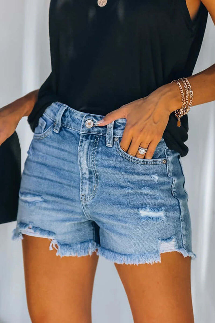 Women's chic blue ripped denim shorts, perfect for a casual summer style. Trendy distressed women's shorts.