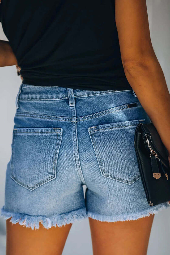 Chic women's ripped blue denim shorts with distressed details. Versatile for everyday casual summer outfits.