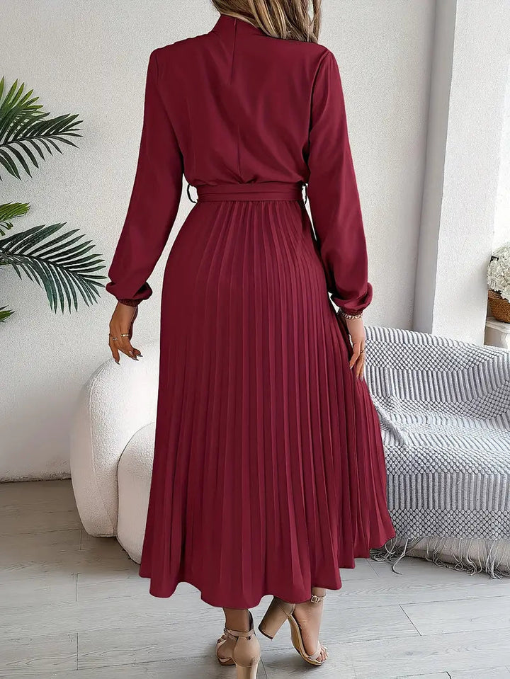 Women's formal pleated midi dress, elegant with belt, long sleeves & high neck. Ideal special occasion dress.