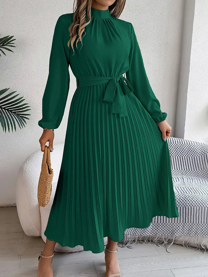 Belted women's midi dress, elegantly pleated with long sleeves & a high neck. Wedding guest style.