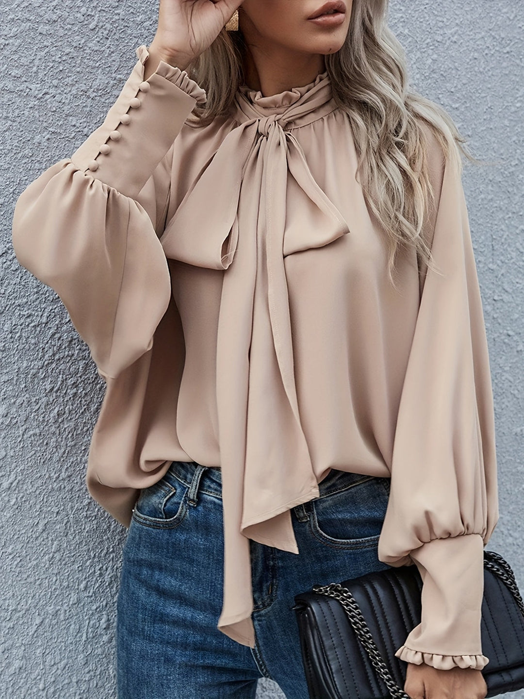 Chic women's top featuring a sophisticated tie neck, long sleeves, and graceful ruffle cuffs.