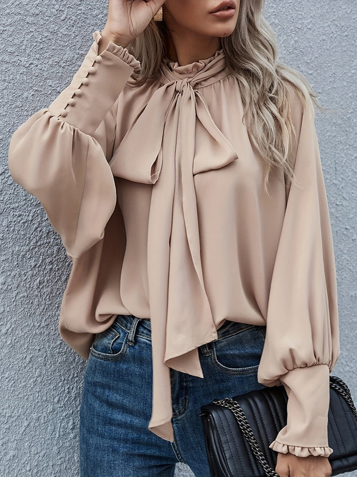 Chic women's top featuring a sophisticated tie neck, long sleeves, and graceful ruffle cuffs.