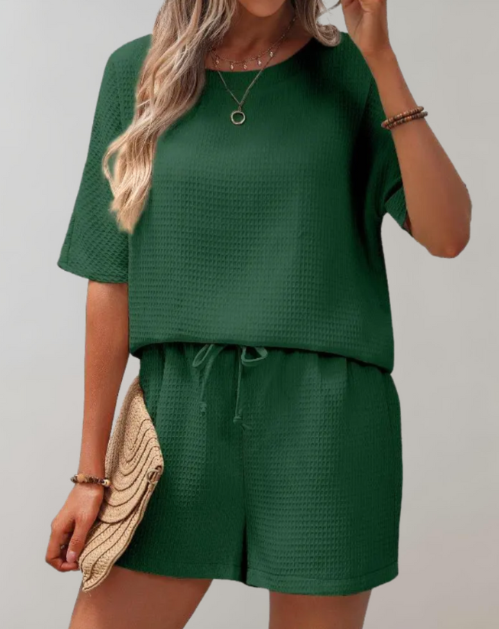Trendy women's two-piece outfit featuring a stylish top and loose fit shorts, great for summer fashion & vacations.