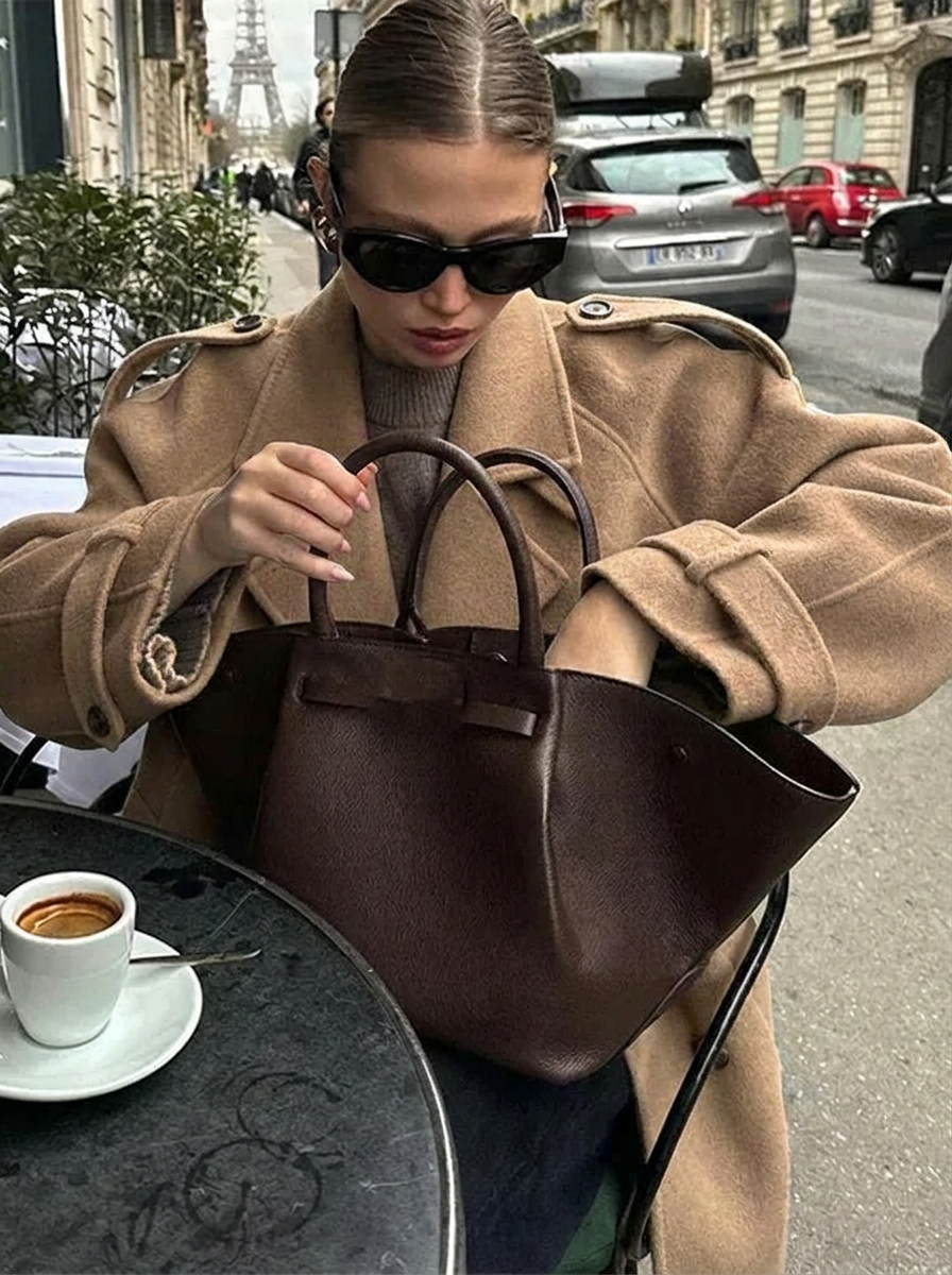 Fashionable women's brown double-breasted cropped trench coat. Classic style statement coat, perfect for fall outerwear.