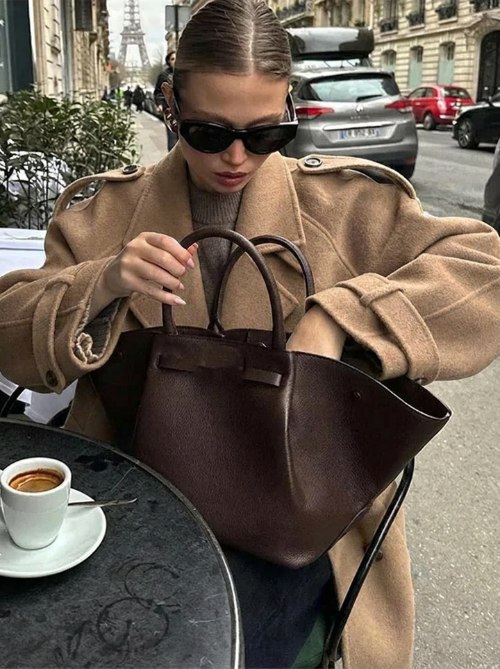 Fashionable women's brown double-breasted cropped trench coat. Classic style statement coat, perfect for fall outerwear.