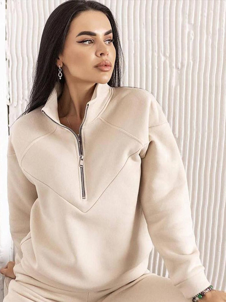 Soft women's casual tracksuit featuring a comfortable zip-neck long-sleeve top and matching tapered trousers.