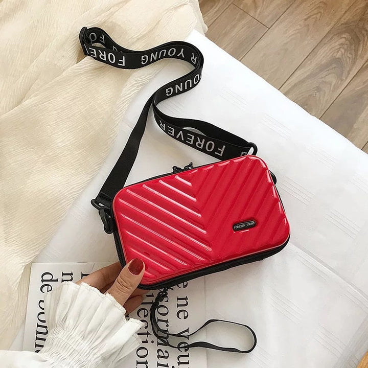 Sleek women's vegan leather hard shell mini bag. Stylish compact crossbody for travel accessories.