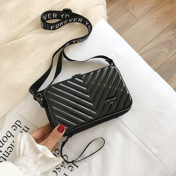 Compact hard shell crossbody travel bag for women. Durable mini handbag with secure zippered closure.