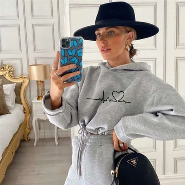 Stylish women's two-piece set: trendy hooded sweatshirt and matching fitness leggings for casual wear.