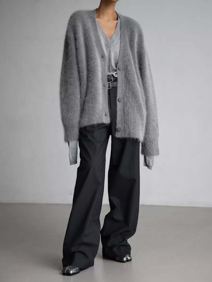 Woman relaxing in a cozy fluffy knit cardigan sweater, perfect warm long sleeve for comfortable winter days.