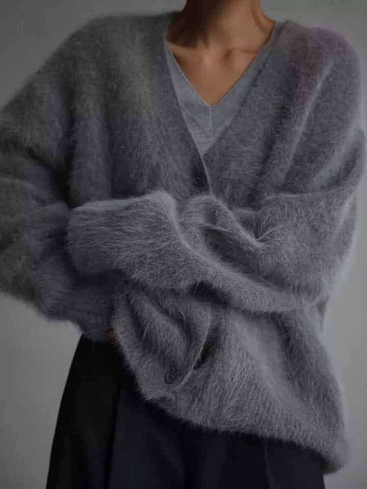 Close-up of the intricate knit pattern on a women's fluffy cardigan sweater, soft, cozy, and warm.