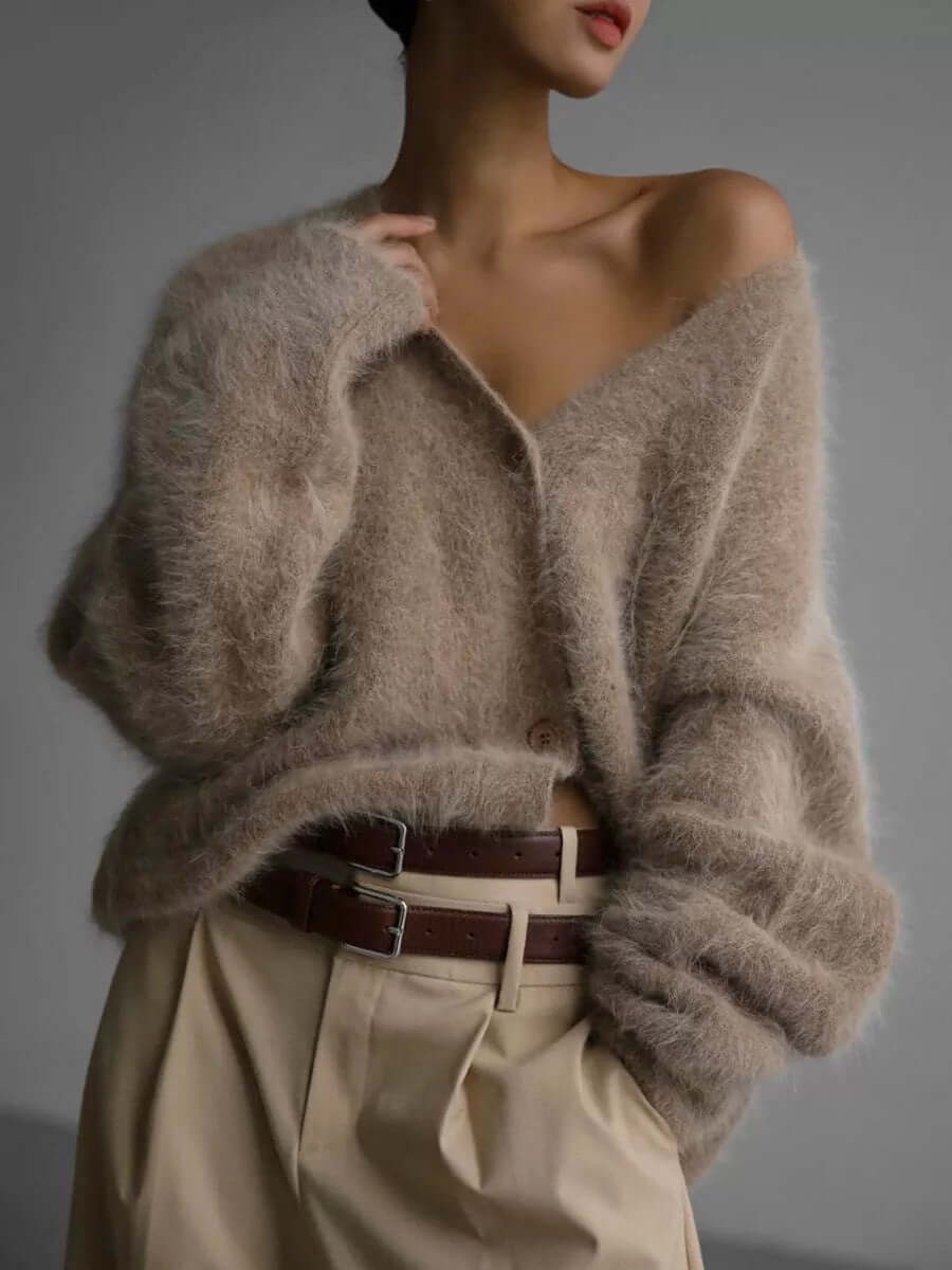 Close-up of soft knit fluffy texture on a women's cozy cardigan sweater, comfortable winter fashion.