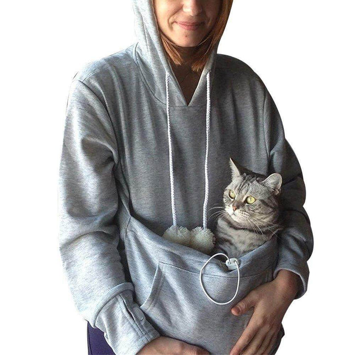 A woman wearing a comfy hoodie with her cat nestled safely in the front animal pouch.