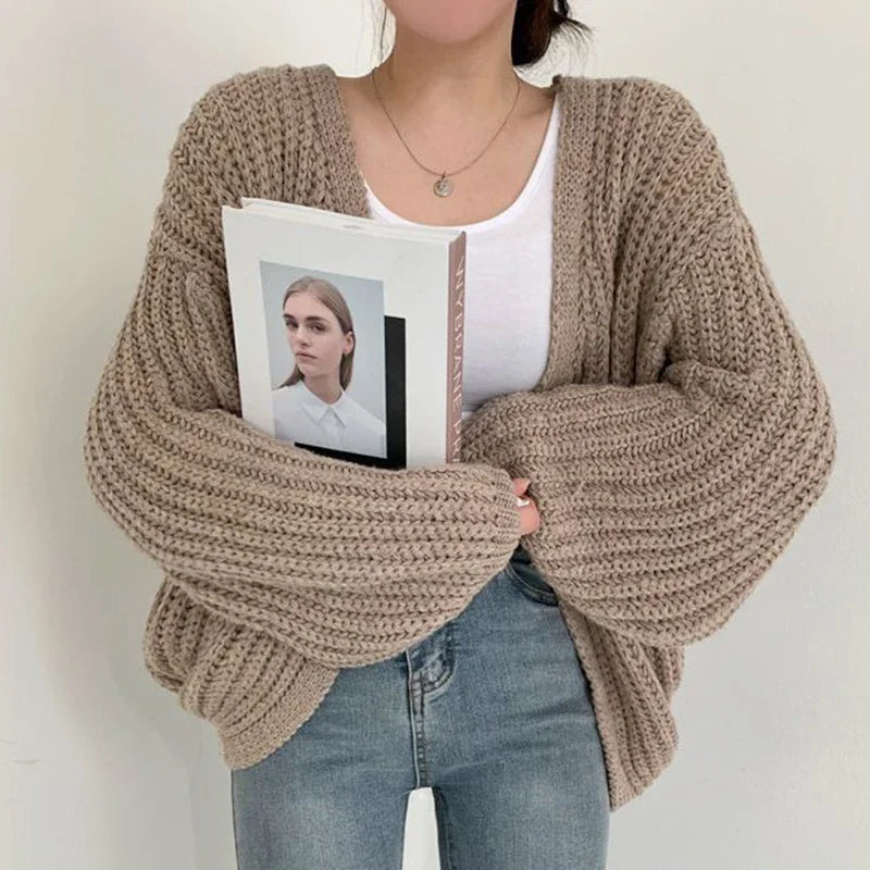 Chunky knit women's open-front cardigan featuring stylish oversized lantern sleeves. Ideal cozy layering piece.