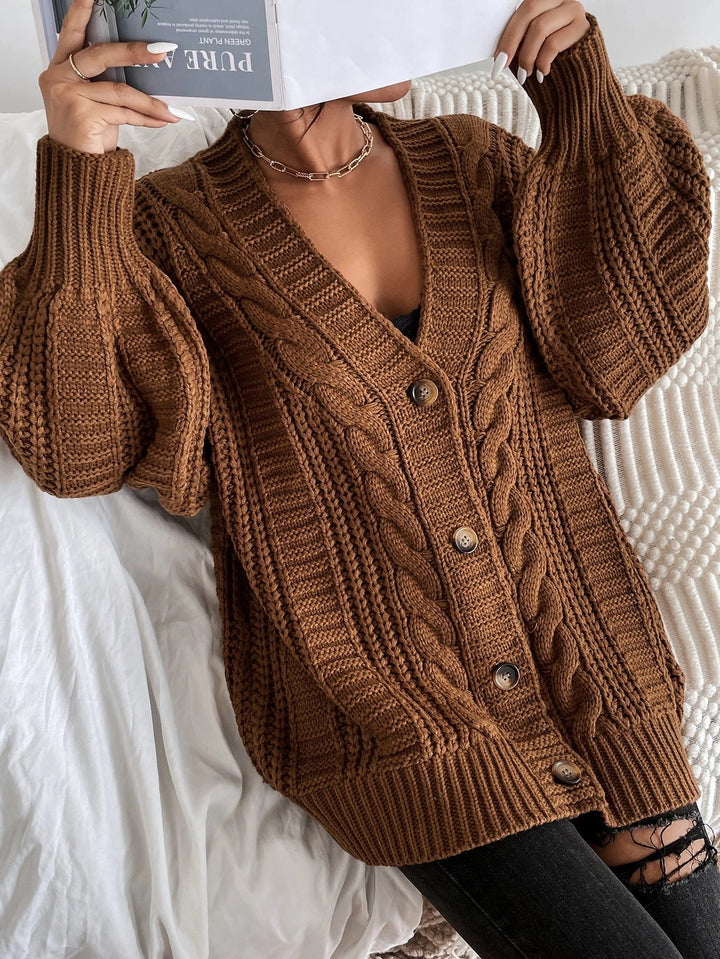 Detailed cable pattern on a women's oversized cardigan. Cozy, relaxed fit, perfect for winter layering & comfort.