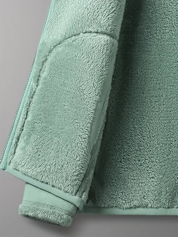 Snug stand collar detail on a women's reversible winter jacket, providing extra neck warmth and style.