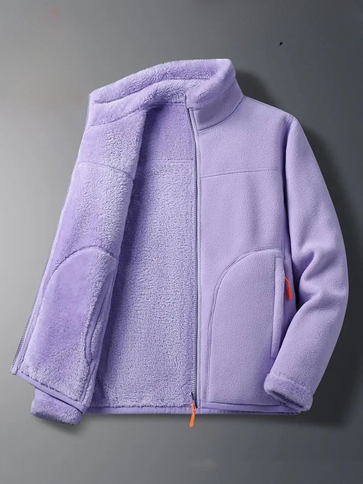 Woman wearing a cozy reversible zip-up winter jacket with stand collar for casual fall fashion.