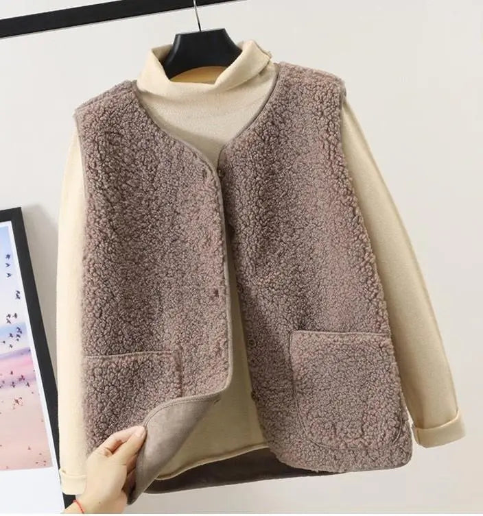 Women's fashionable beige fleece vest with textured fabric, offering warmth & a chic layer for any season.