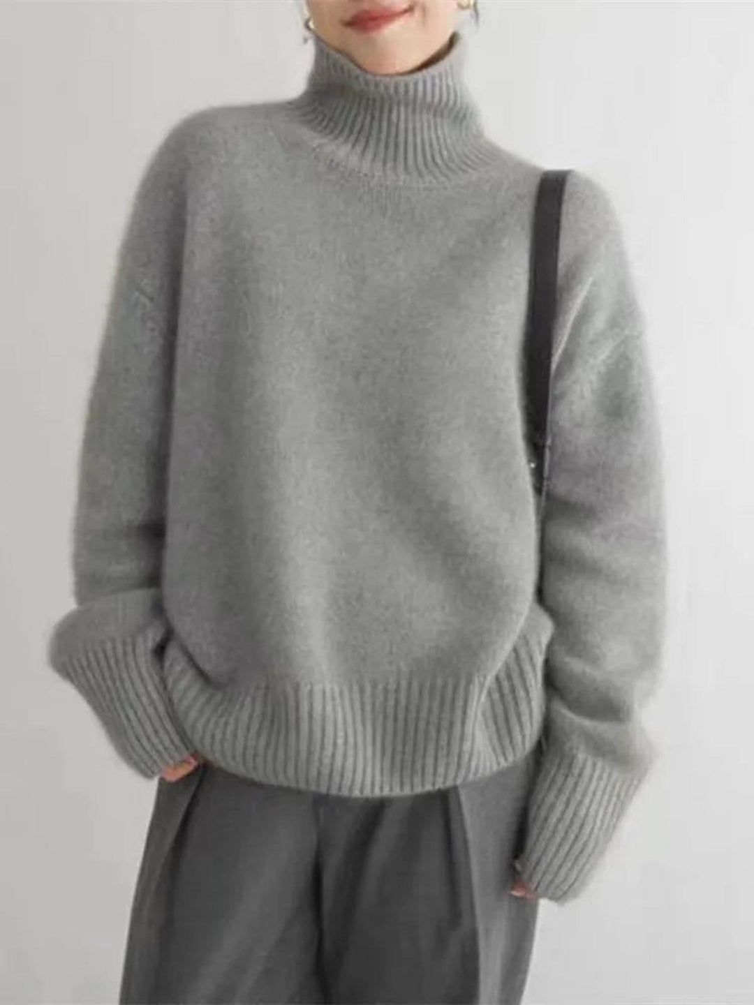 Close-up of a khaki women's cozy turtleneck sweater, showcasing its soft knit and relaxed fit.