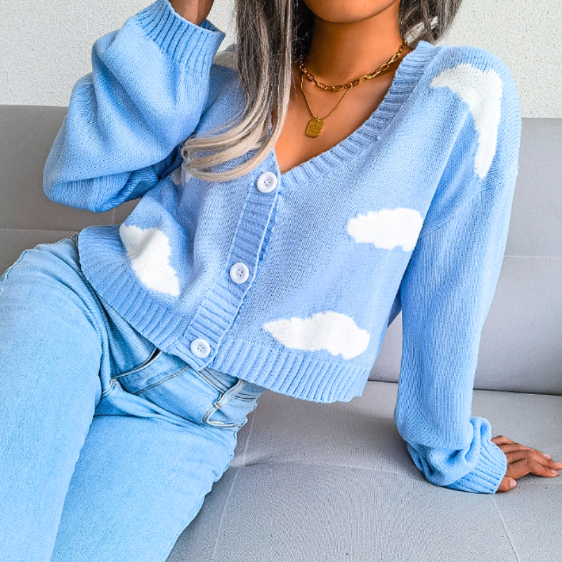 Pink women's cropped cardigan with unique cloud print. Stylish V-neck button-up top.