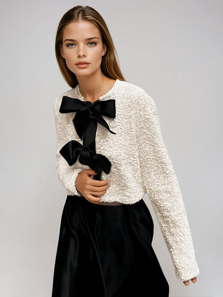 Women's dazzling beige cropped jacket with decorative bows, perfect for eveningwear & special occasions.