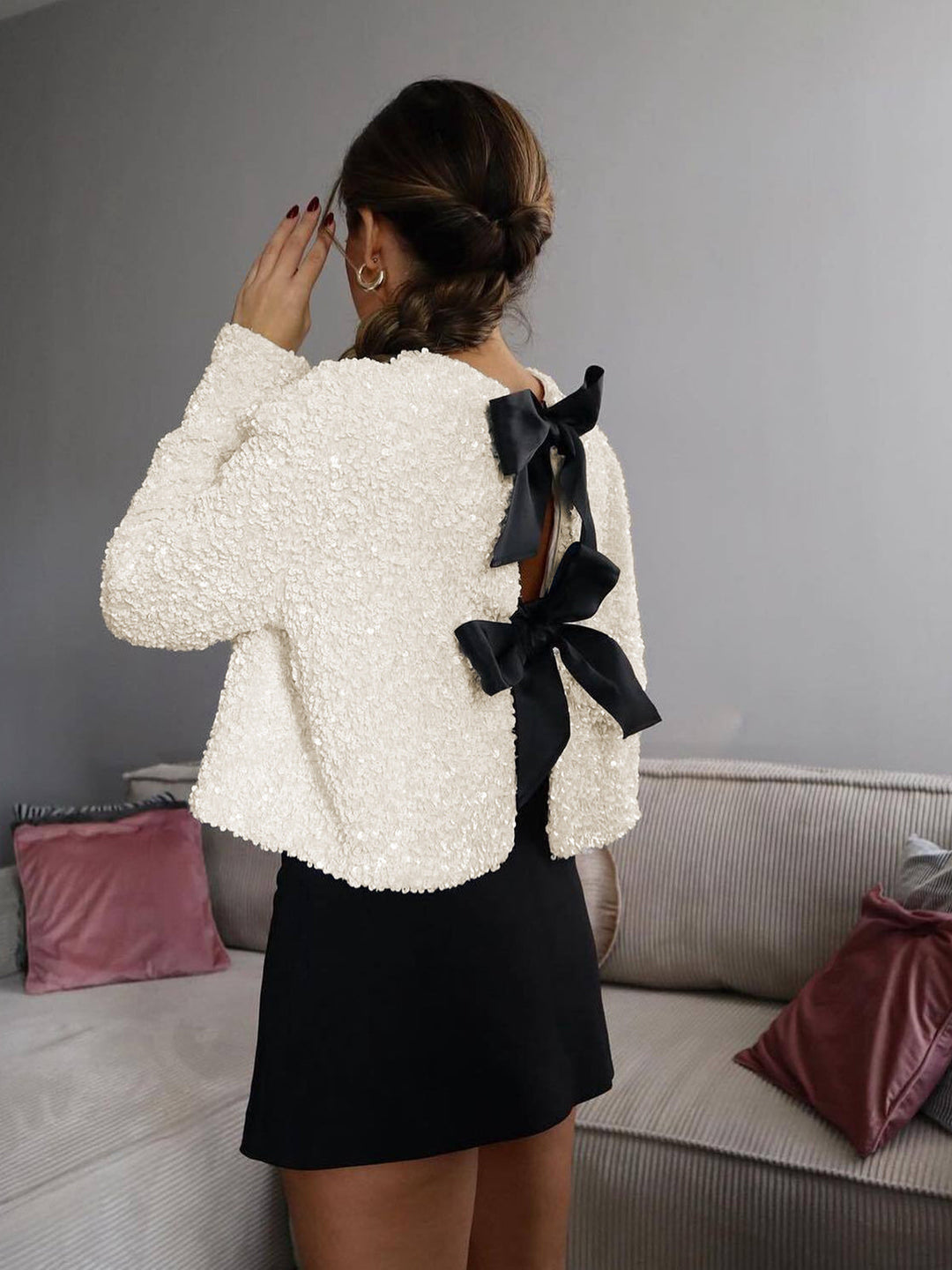 Glamorous women's beige cropped jacket, a dazzling outerwear statement piece with elegant bows.