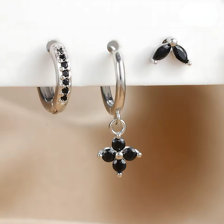 Women's ear piercing set with surgical steel studs, hoops, and cubic zirconia for comfortable style.