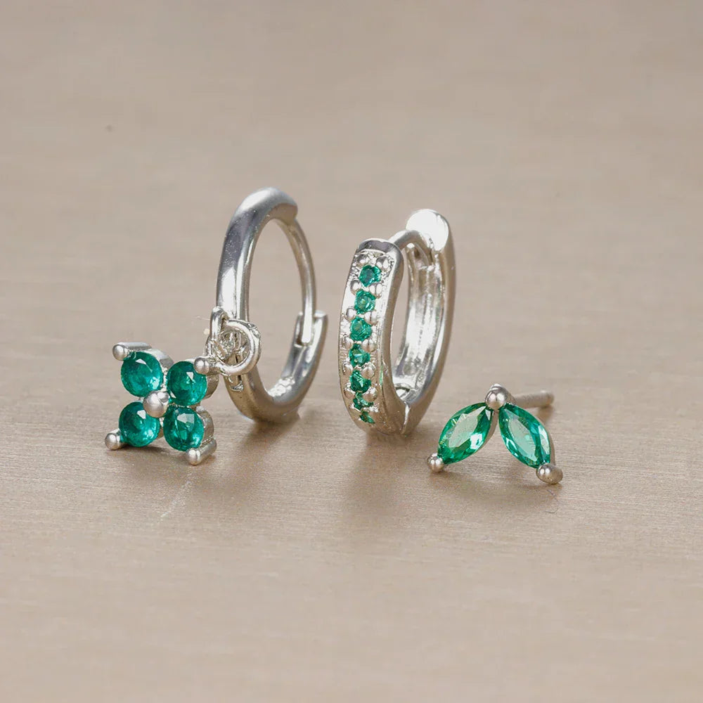 Elegant women's ear piercing set featuring surgical steel studs, hoops, and sparkling cubic zirconia jewelry.