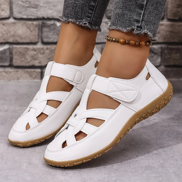 Comfortable women's walking sandals with easy-wear cutouts and adjustable Velcro for warm weather.