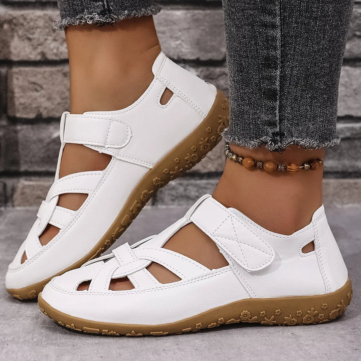 Flat women's casual sandals with a unique cutout design and practical adjustable Velcro straps.