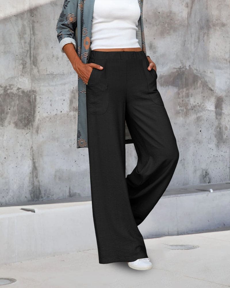 Woman wearing chic wide leg trousers paired with a simple top, showcasing a relaxed and fashionable look.