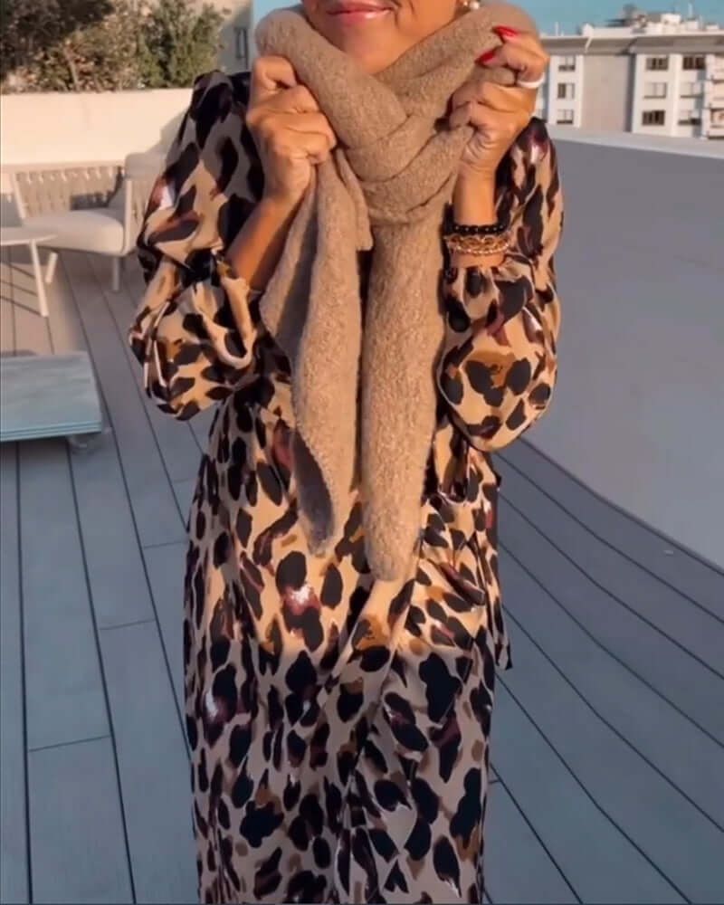 Full view of a women's flowing leopard print V-neck midi dress, highlighting its comfortable, casual fit.