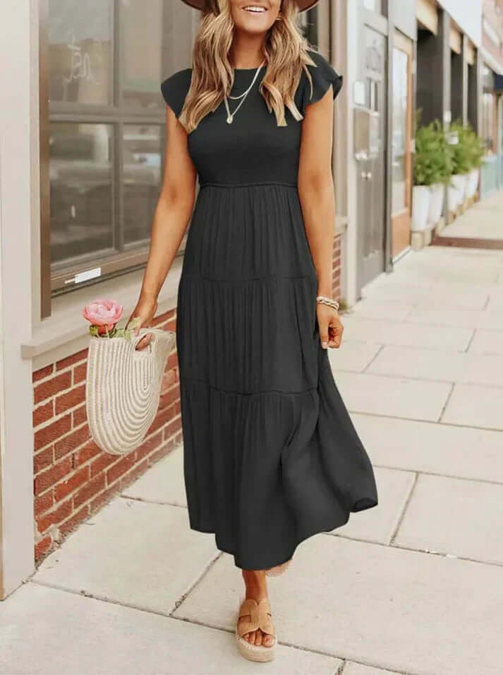 Close-up of the elegant pleated skirt and graceful flutter sleeves on a women's midi A-line dress, fashion detail.