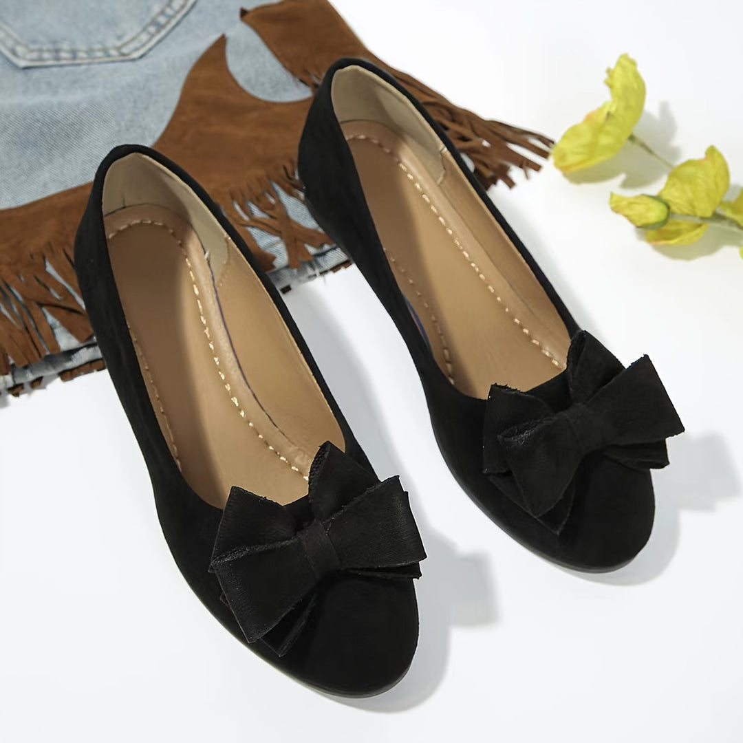 Women's everyday footwear: comfortable wedge shoes with bow detail.
