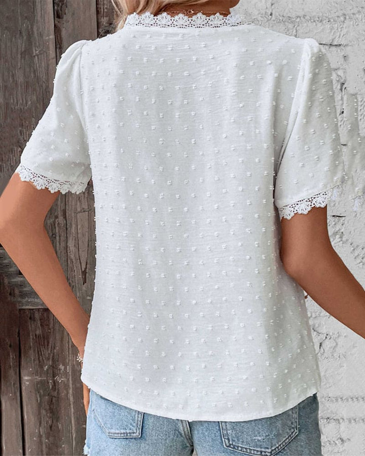 Women's white textured V-neck blouse styled for a casual chic summer outfit, perfect for warm weather and holidays.