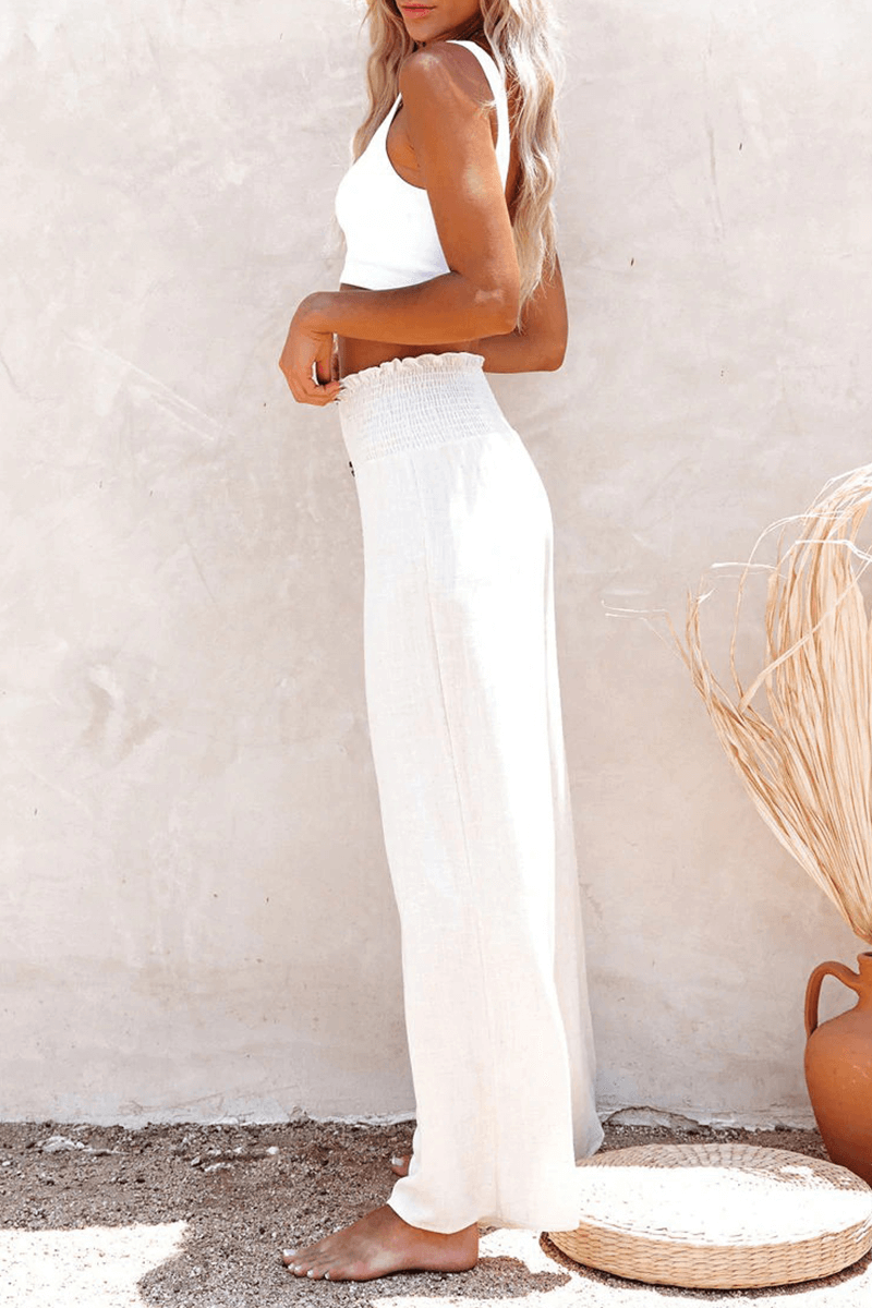 Model wears comfortable wide leg women's trousers with button closure, styled for an elegant spring look.