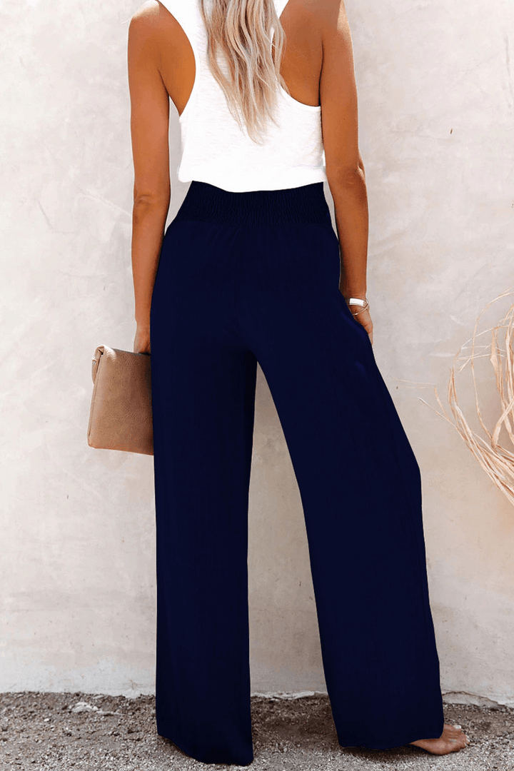 Elegant polyester women's wide leg trousers with prominent button closure, offering a comfortable loose fit.