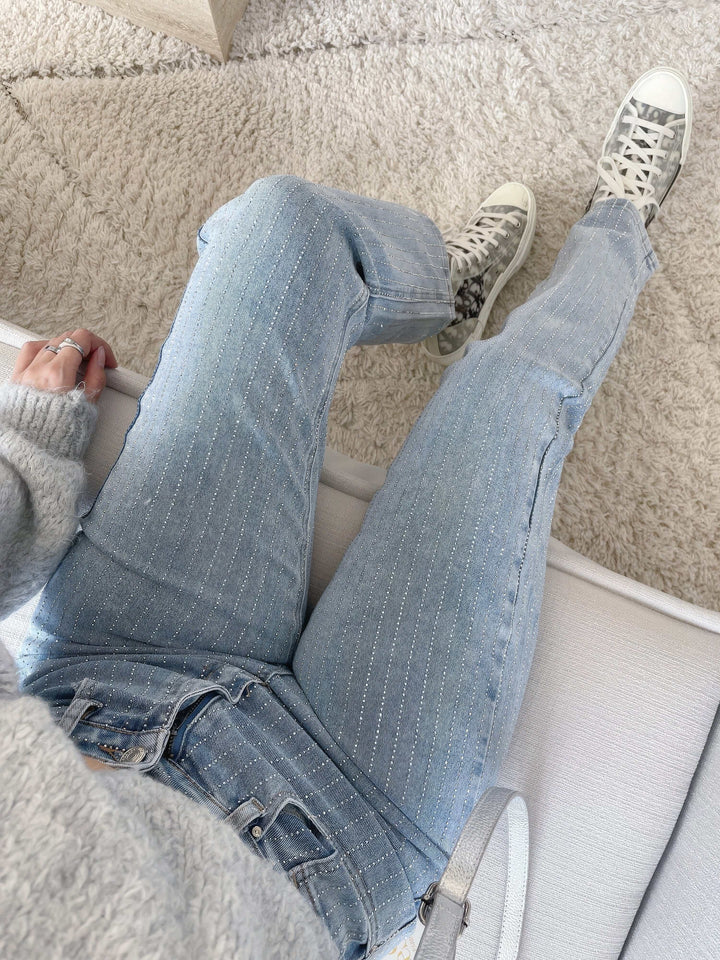 Close-up of stylish embellishments on women's straight leg denim jeans. Modern casual pants.